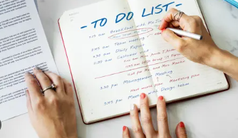 Seseorang menulis daftar tugas harian di buku catatan